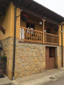 ein Haus mit einem Balkon und einer Holztür in der Unterkunft LA CASA DE LOS GÜELOS in Bada