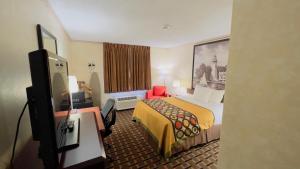 a hotel room with a bed and a tv at Super 8 by Wyndham Maumee Perrysburg Toledo Area in Maumee