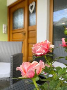 塞博登的住宿－Haus Seerose，一张桌子上满是粉红色玫瑰的花瓶