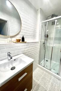 a white bathroom with a sink and a shower at les suites du beffroi 2 in Calais +8 photos