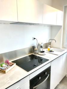 a kitchen with a sink and a stove top oven at les suites du beffroi 2 in Calais