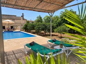 a patio with two chairs and a swimming pool at Can Biel in Pina