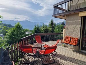 a deck with chairs and a table with a view of mountains at Chalet du Vernay in Saint-Gervais-les-Bains