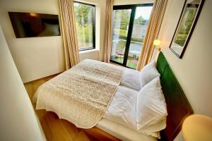 a bedroom with a white bed with a window at SIRENA in Palanga
