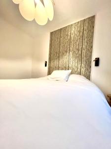 a bedroom with a large white bed with a window at les suites du beffroi in Calais +12 photos