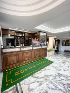 un vestíbulo del hotel con un bar con una alfombra verde de bienvenida en Hotel 2000, en Giugliano in Campania