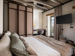 a bedroom with a large bed with a flat screen tv at Rastoni home - Rethimno, Crete - Enjoy your slow-travel mindset in Áyios Yeóryios