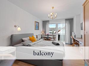 1 dormitorio con 1 cama y sala de estar en Schicke Ferienwohnung in bester Lage mit Sonnenbalkon l Innenstadtnähe l 1 Minute zum Bahnhof l Küche l Großer Schreibtisch l TV l Free-WLAN l Willkommen im Hallo!-Apartment 13 en Bad Wörishofen