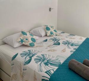 un letto con piumone e cuscini sopra di Apartmani Begic 1 i 2 a Barbat na Rabu