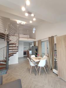 a living room with a table and chairs and a staircase at Apartmani Begic 1 i 2 in Barbat na Rabu