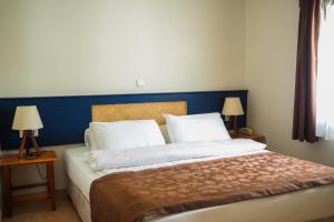 a bedroom with a bed with a blue headboard and two lamps at Oya Butik Otel in Bodrum City