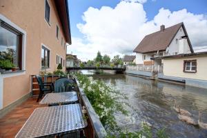 a balcony with tables and chairs next to a river at Hotel Ricci in Rust