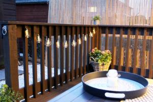 a table on a deck with a fence with lights at Luxurious Apartment with South facing Garden in Perth