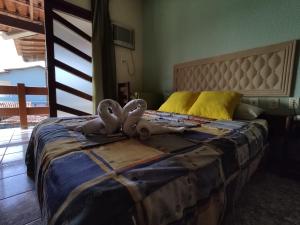 a bedroom with a large bed with a large headboard at Hotel Pousada Guayporã in Guarapari