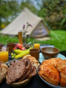 a table topped with bread and pastries and orange juice at SENSI - 'FIRE' Restaurant and Glamping in Oostkamp