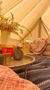 um quarto com uma tenda com uma mesa e flores em SENSI - 'FIRE' Restaurant and Glamping em Oostkamp