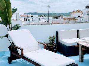 een paar stoelen en een tafel op een balkon bij ABA DALÍ in Conil de la Frontera