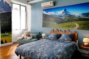 a bedroom with a teddy bear sitting on a bed at Le grand Houx in Orthez