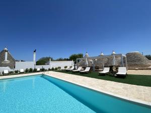 阿爾貝羅貝洛的住宿－i Trulli del Fauno，游泳池周围设有躺椅和椅子