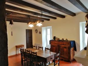 uma sala de jantar com uma mesa de madeira e cadeiras em Grande maison de ville avec cheminée et loggia em Lacapelle-Biron