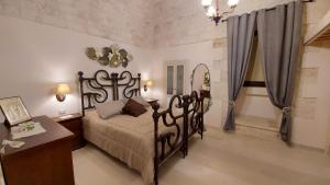 une chambre avec un lit, une table et un miroir dans l'établissement Locorotondo Stone House, à Locorotondo