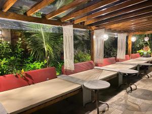a row of benches in a restaurant with plants at Villa Sapê Pousada in Ubatuba