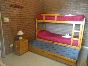 a room with two bunk beds in a brick wall at Cabañas Bosque in Villa Carlos Paz +37 photos