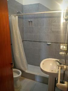 a bathroom with a shower and a toilet and a sink at Cabañas Bosque in Villa Carlos Paz