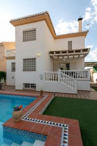 a villa with a swimming pool in front of a house at Casa de la Vega in Cúllar-Vega