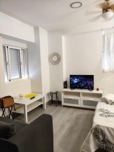 a white living room with a flat screen tv at LOFTS ARENAL in Madrid