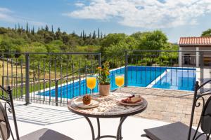 uma mesa com comida e bebidas numa varanda com piscina em Casa di Pietra em Sibenik