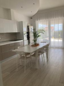 a kitchen with a white table with chairs and a table and a tableablish at Matera Villa Mater in Matera