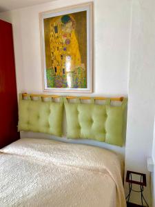 une peinture au-dessus d'un lit dans une chambre dans l'établissement Largo piano, à Scilla