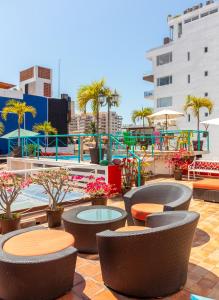 un patio con mesas y sillas y una piscina en La Iguana Vallarta LGBT - Romantic Zone - Party Clubbing Street, en Puerto Vallarta