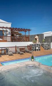 una piscina con una bottiglia di vino su un patio di Villa Sea Breeze Ocean View a Playa Blanca