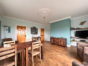 a dining room with a table and chairs and a television at Errigal View B&B and Crafts in Fawnaboy Lower