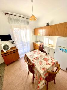 a small kitchen with a table and a refrigerator at Largo piano in Scilla