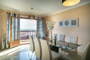una sala da pranzo con tavolo e sedie e una grande finestra di Villa Sea Breeze Ocean View a Playa Blanca