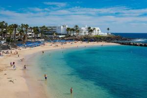 un gruppo di persone su una spiaggia vicino all'oceano di Villa Sea Breeze Ocean View a Playa Blanca