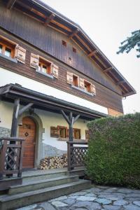 Casa de madera grande con puerta y porche en Chalet Belle-Sofianna, en Saint-Gervais-les-Bains
