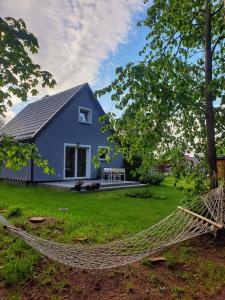 a blue house with a hammock in front of it at Siedlisko na Ustroniu in Sasino
