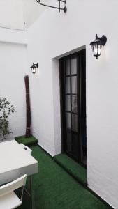 
a room with a white wall and a blue door at Hotel y Apartamentos Doña Lola in Seville
