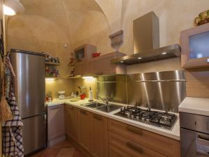 a kitchen with a stove and a stainless steel refrigerator at Apartment Residenza Gabrielli in Sarteano