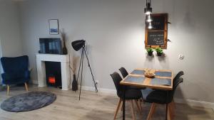 a dining room with a table and chairs and a fireplace at APARTAMENT PIOTR in Iława