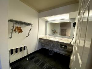 a bathroom with a sink and a large mirror at BridgePoint Inn Daly City in Daly City