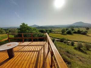 a wooden deck with a table and a view of a field at Moinho do Cubo in Alvorge