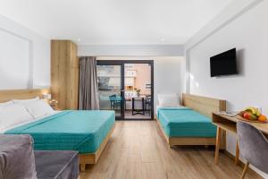 a hotel room with two beds and a television at Anassa Suites in Leptokarya