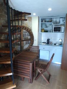 a kitchen with a wooden bench in a room at Moinho do Cubo in Alvorge