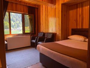 ウズンギョルにあるOzkan Otelのベッドルーム1室(ベッド1台、椅子2脚、窓付)