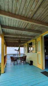 una terraza de madera con mesa y sillas. en Traditional West Indian cottage on Good Moon Farm, en Great Mountain